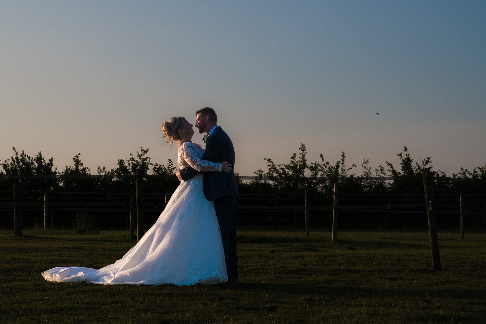 Professional Wedding Photography - A bride and Groom kissing as the sun sets