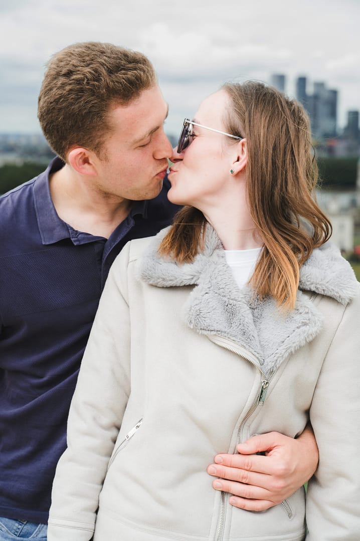 Engagement Photography Shoot, Bedfordshire - A Male in a navy top kissinga girl in sunglasses wearing a cream sheepskin coat
